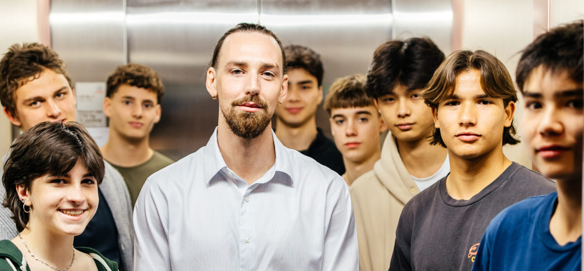 Zach James, founder of The Youth Career Counsellor, standing with a group of young people in an elevator.